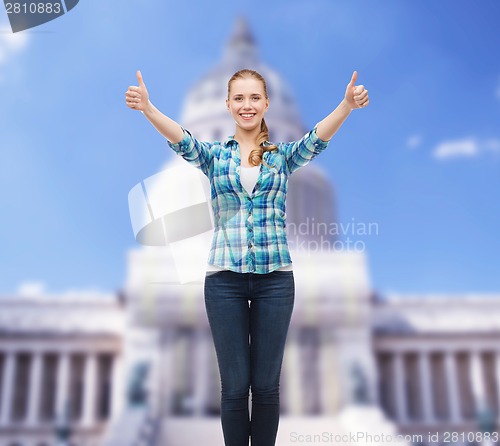 Image of smiling girl in casual clothes showing thumbs up