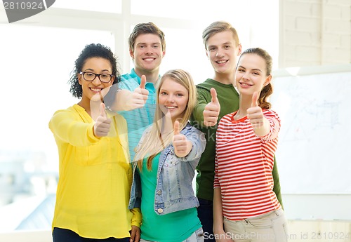 Image of five smiling showing thumbs up at school