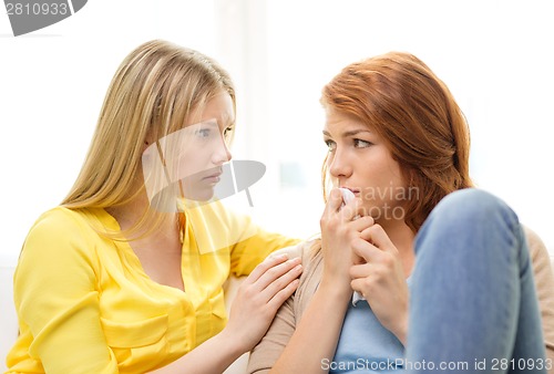 Image of one teenage girl comforting another after break up