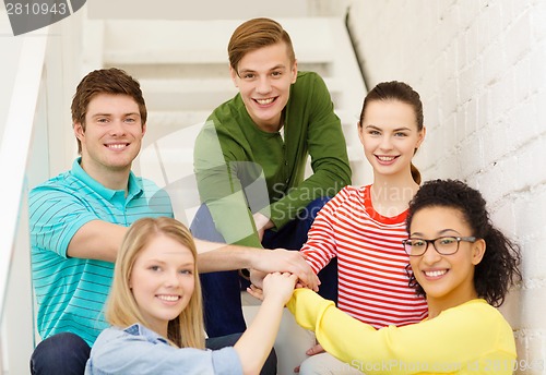 Image of smiling students with hands on top of each other