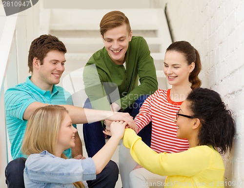 Image of smiling students with hands on top of each other