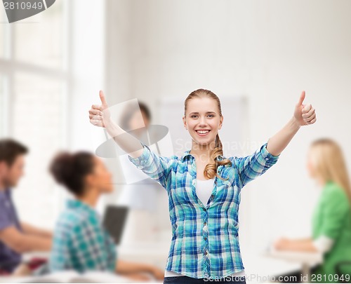 Image of smiling girl in casual clothes showing thumbs up