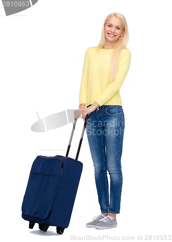 Image of smiling young woman with suitcase