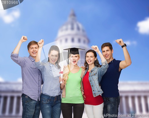 Image of group of standing smiling students with diploma