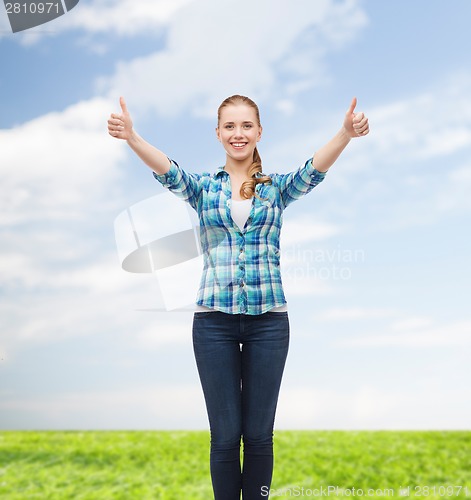 Image of smiling girl in casual clothes showing thumbs up
