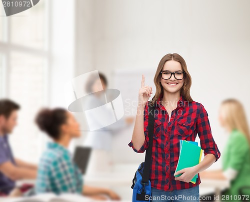 Image of smiling female student with bag and notebooks