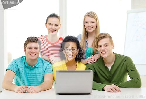 Image of smiling students with laptop at school