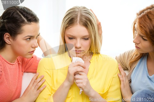 Image of two teenage girls comforting another after breakup