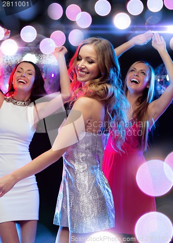 Image of three smiling women dancing in the club