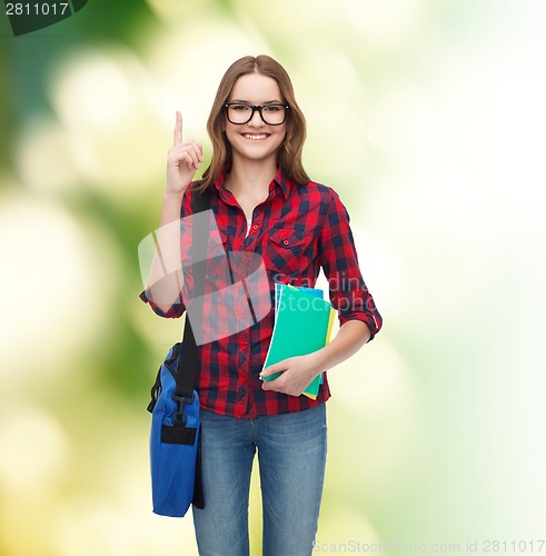 Image of smiling female student with bag and notebooks