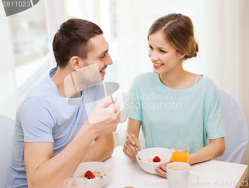 Image of smiling couple having breakfast at home