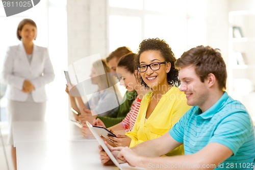 Image of smiling female students with tablet pc at school