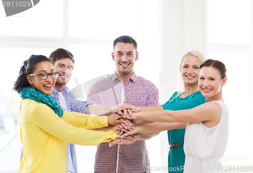 Image of team with hands on top of each other in office