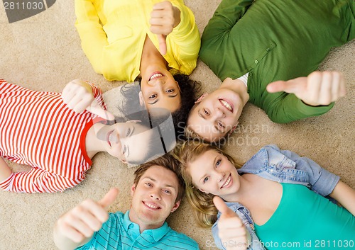 Image of group of smiling people lying down on floor