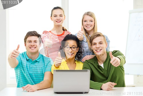 Image of smiling students with laptop at school