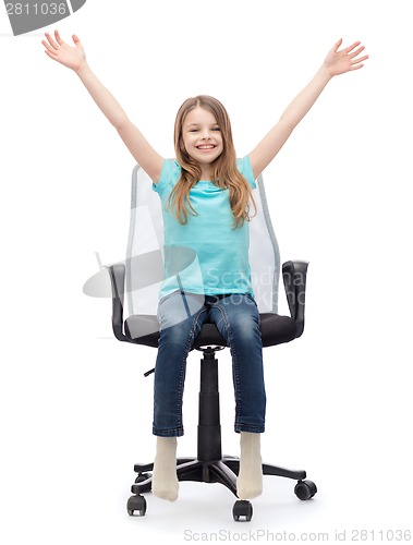 Image of smiling little girl sitting in big office chair