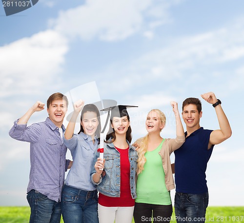 Image of group of standing smiling students with diploma