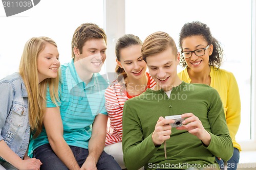 Image of smiling students with digital camera at school
