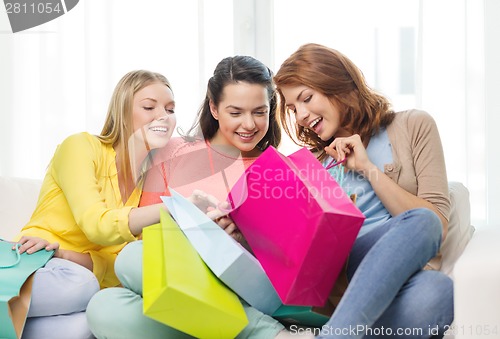 Image of smiling teenage girls with many shopping bags