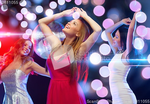Image of three smiling women dancing in the club