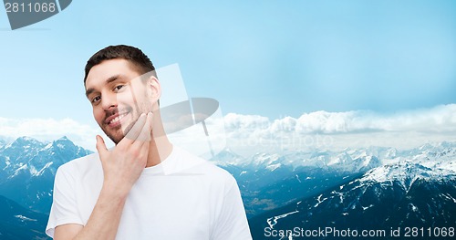 Image of beautiful smiling man touching his face