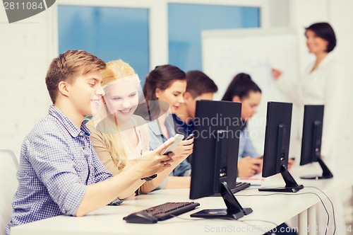 Image of students with computer monitor and smartphones