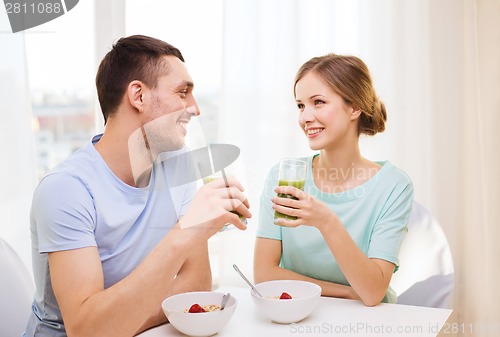 Image of smiling couple having breakfast at home