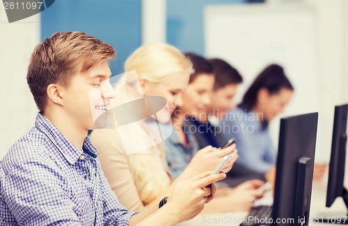 Image of students with computer monitor and smartphones