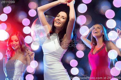 Image of three smiling women dancing in the club