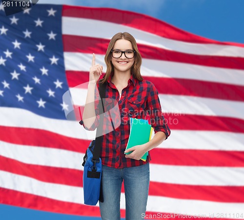 Image of smiling female student with bag and notebooks