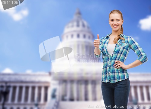 Image of young woman in casual clothes showing thumbs up