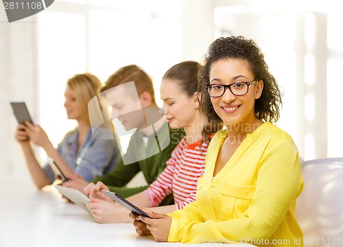 Image of smiling female students with tablet pc at school