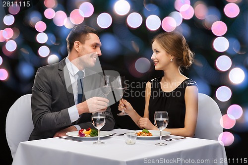 Image of smiling couple eating main course at restaurant