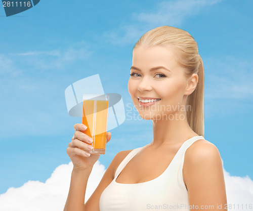 Image of smiling woman holding glass of orange juice