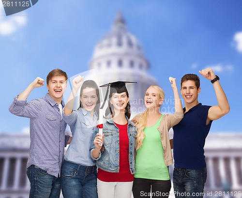 Image of group of standing smiling students with diploma