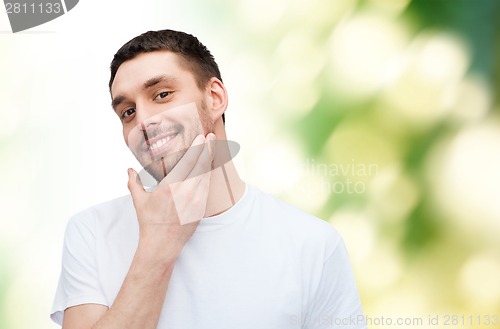 Image of beautiful smiling man touching his face