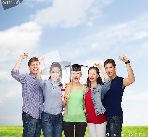 Image of group of standing smiling students with diploma