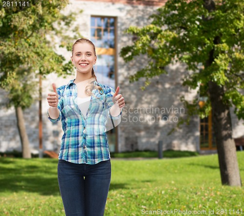 Image of young woman in casual clothes showing thumbs up