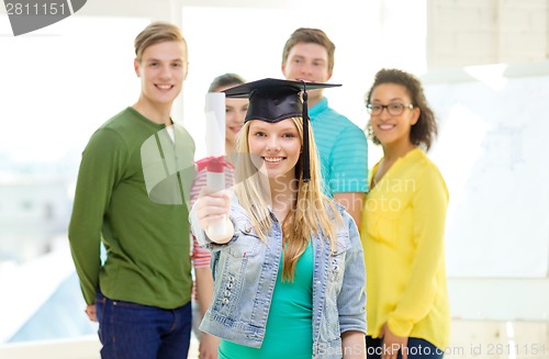 Image of smiling female student with diploma and corner-cap