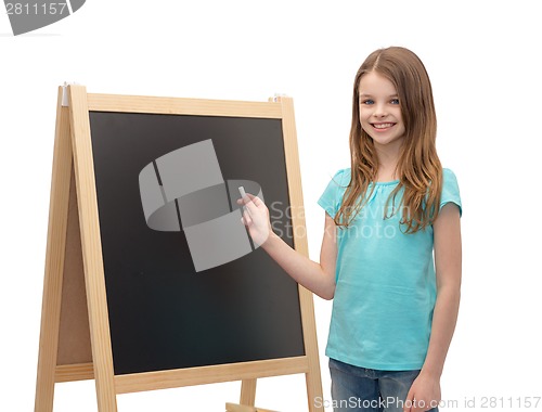 Image of happy little girl with blackboard and chalk