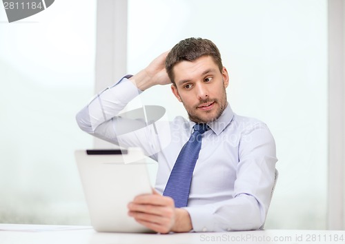 Image of stressed businessman with tablet pc and documents