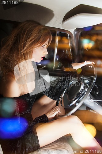 Image of glamorous woman behind the wheel in the car