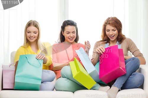 Image of smiling teenage girls with many shopping bags