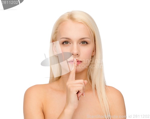 Image of calm young woman with finger on lips