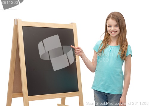 Image of happy little girl pointing finger to blackboard