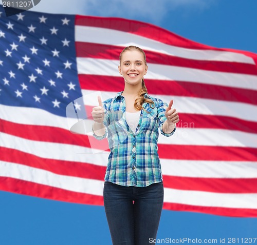 Image of young woman in casual clothes showing thumbs up