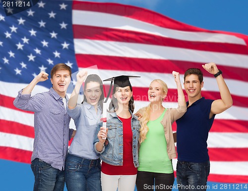 Image of group of standing smiling students with diploma