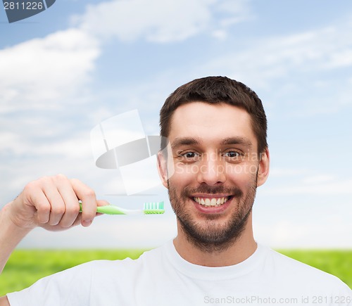 Image of smiling young man with toothbrush