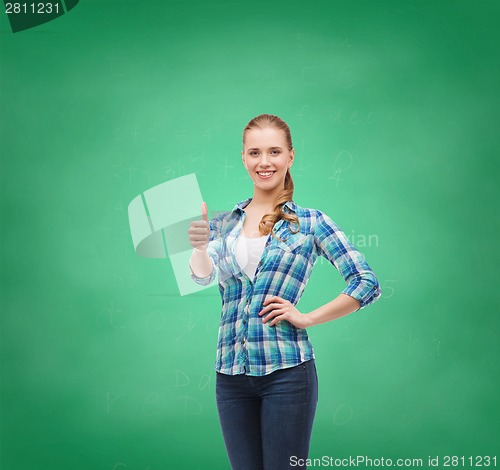 Image of young woman in casual clothes showing thumbs up