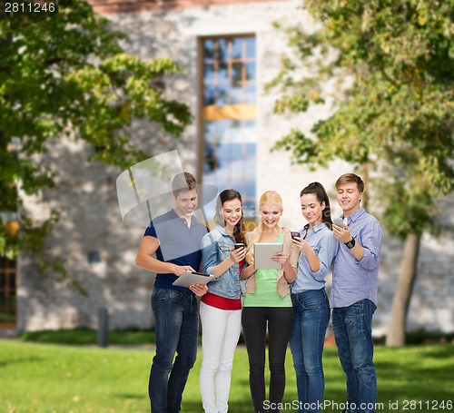 Image of smiling students using smartphones and tablet pc
